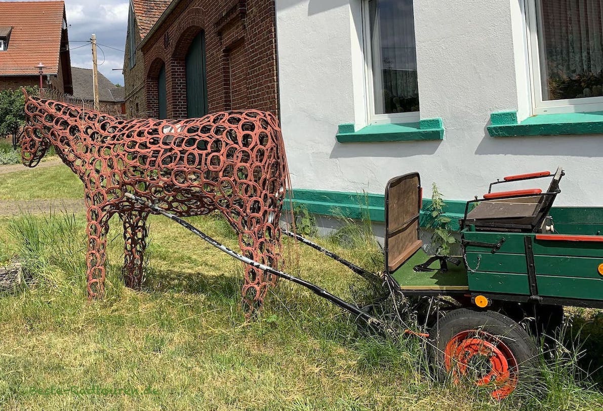 Kunst in Ahrensdorf (Nuthe-Urstromtal): Hufeisenpferd mit altem Leiterwagen