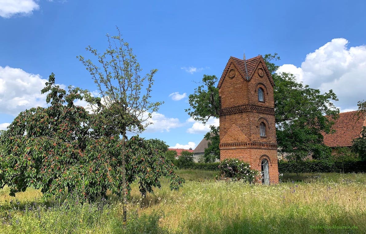 Im hinteren Teil von Schloss Kleßen: Wirtschaftshof (rechts), Wasserturm und wilder Park