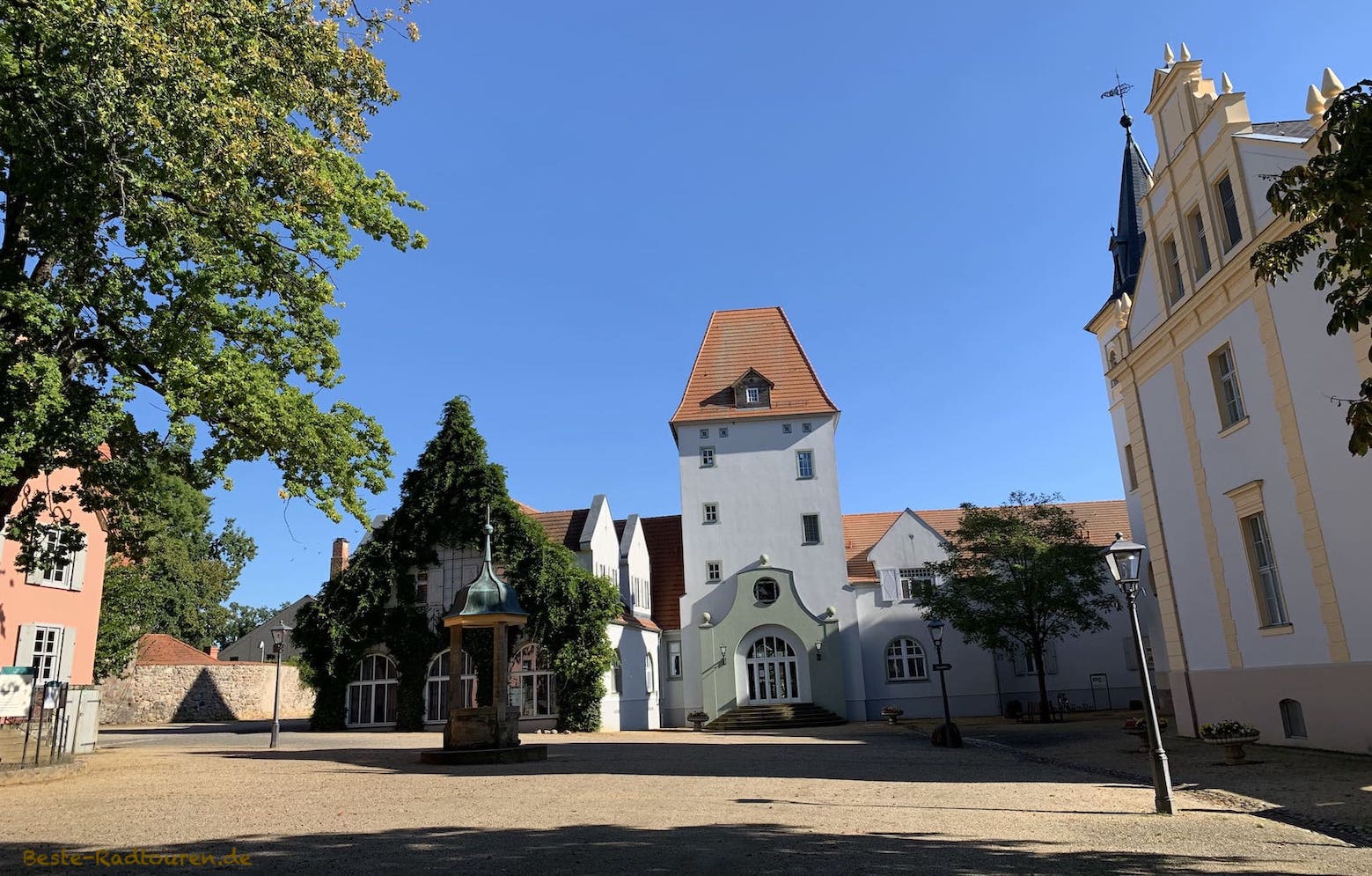 Im Schlosshof von Liebenberg: Geradezu der Torturm, vorne der Kaiserbrunnen, rechts das Gutshaus, links das Inspektorenhaus
