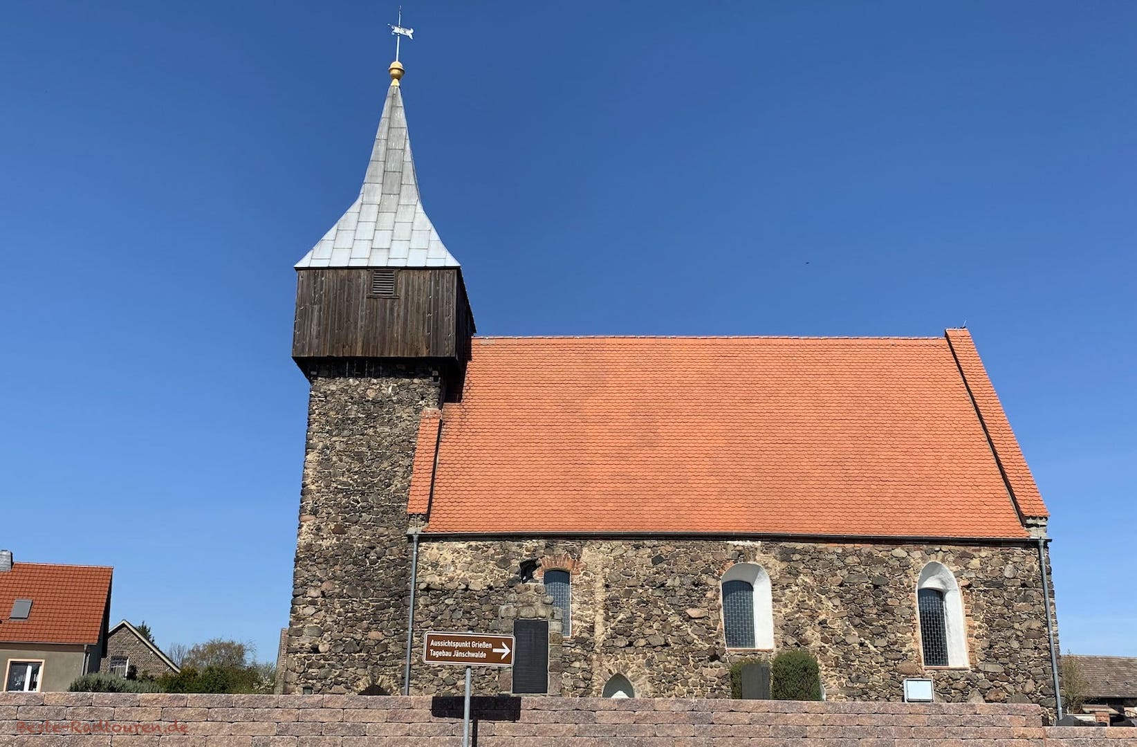 Dorfkirche Grießen mit Wegweiser: "Aussichtspunkt Grießen Tagebau Jänschwalde"
