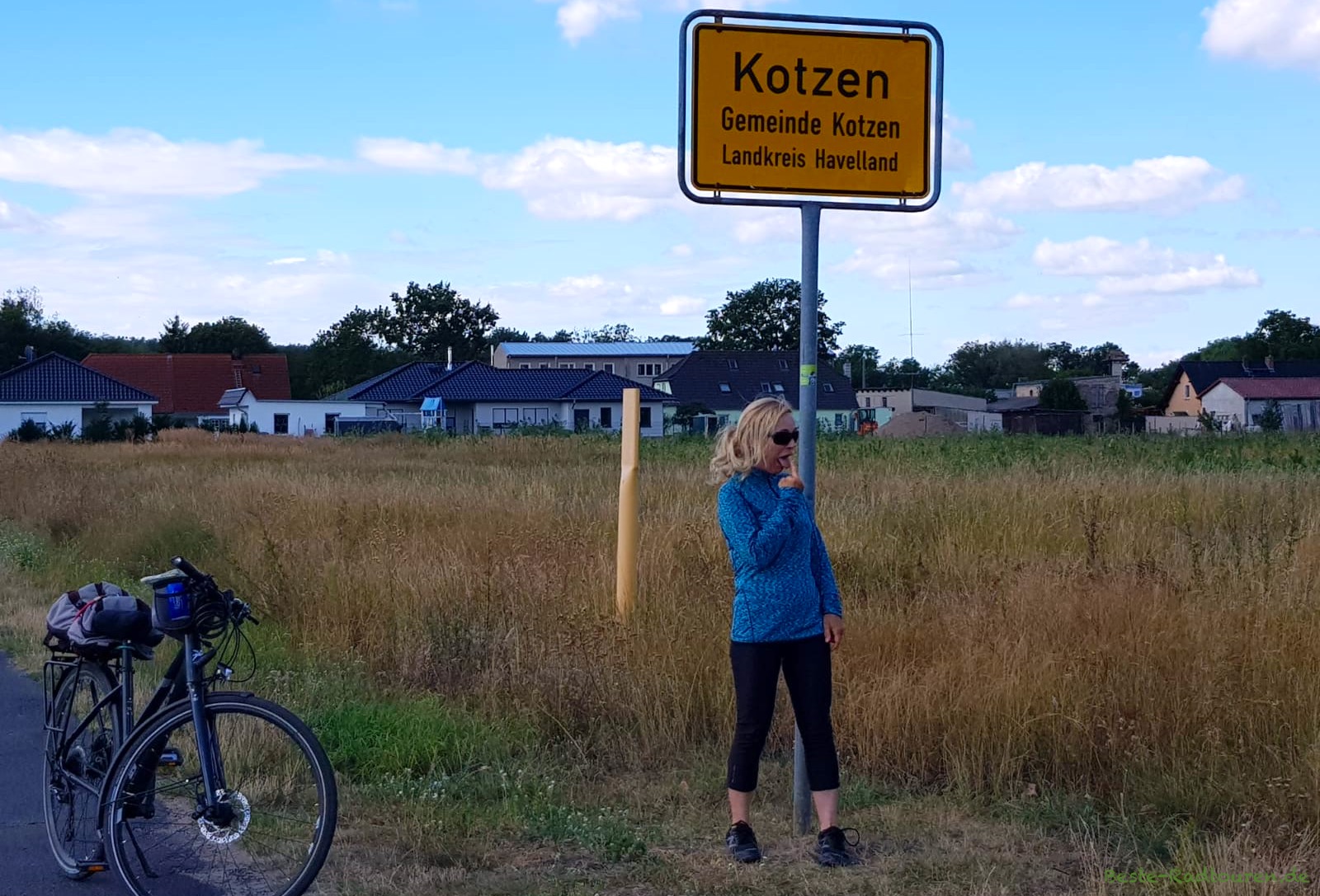 Beste-Radtouren-Frau Beatrice Poschenrieder auf dem Havellandradweg vor dem Ortsschild von Kotzen