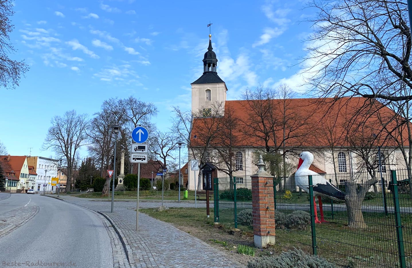 Foto vom Gurken-Radweg aus: Kirche von Burg (Spreewald) und Straße ins Zentrum