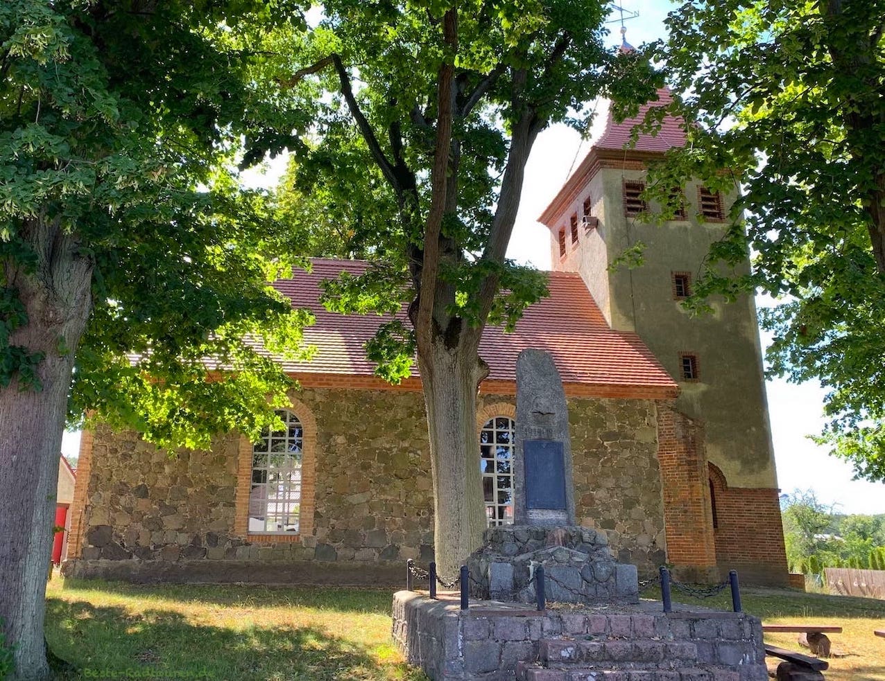Foto vom Radweg aus: Dorfkirche Senftenhütte und Kriegerdenkmal