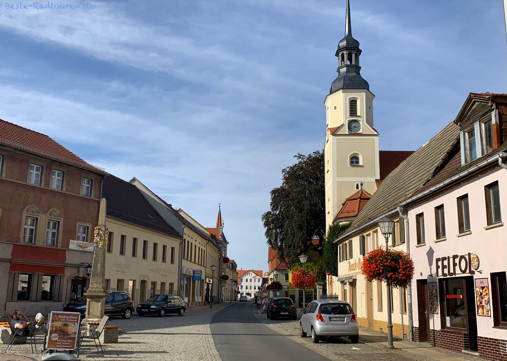 Elsterwerda, Stadtkirche St. Katharina und Postmeilen-Säule; Foto vom Süden her in die Hauptstraße hinein
