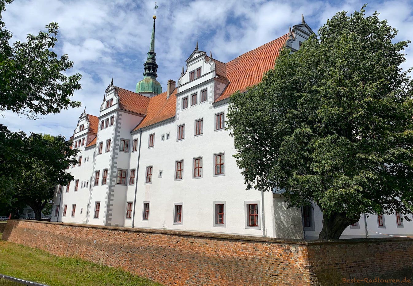Schloss Doberlug, Foto von der Hauptstraße aus, mit Mauer und Schlossgraben
