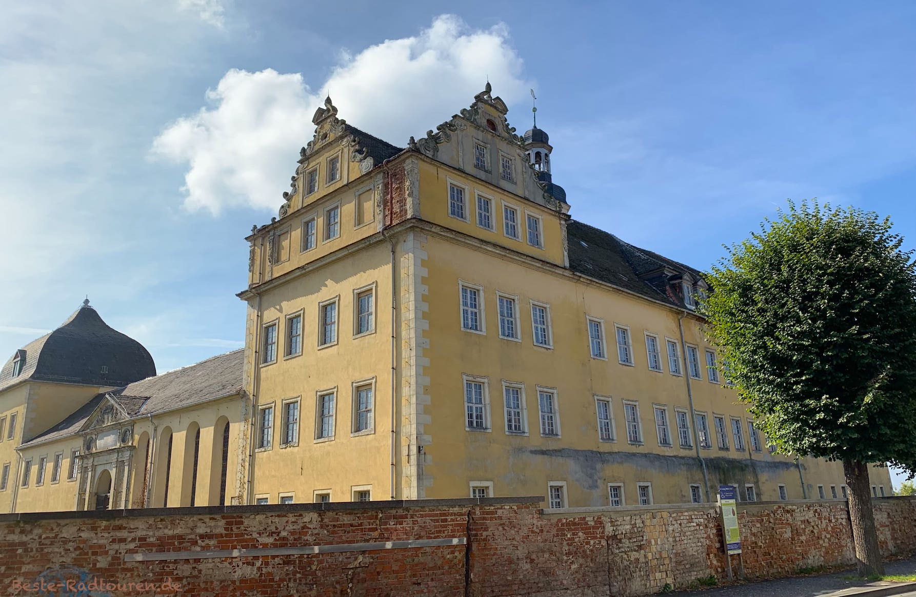 Schloss Coswig (Anhalt), Foto vom Radweg aus, hohe Mauer davor