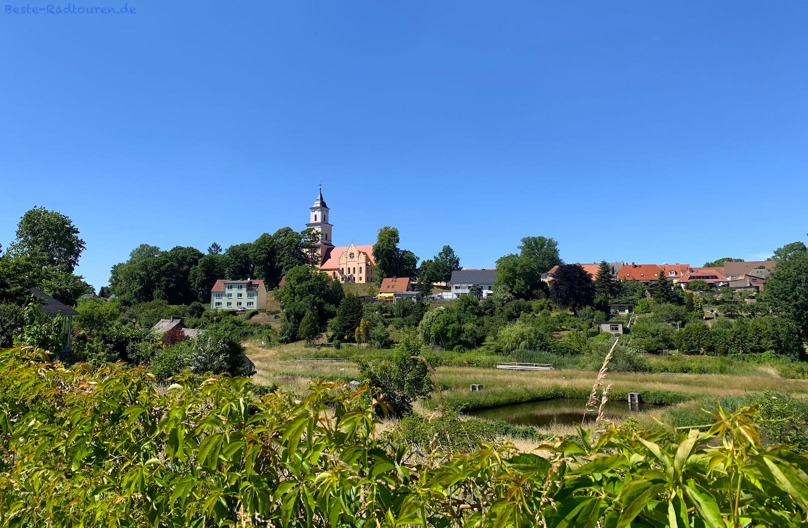 Foto vom Radweg aus: Blick zwischen Klosterruine und Boitzenburg auf Kirche "St. Marien auf Berge"