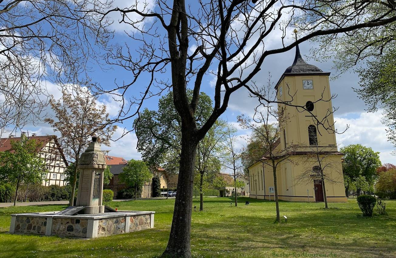Foto im Zentrum von Pausin: Dorfkirche und Kriegsdenkmal